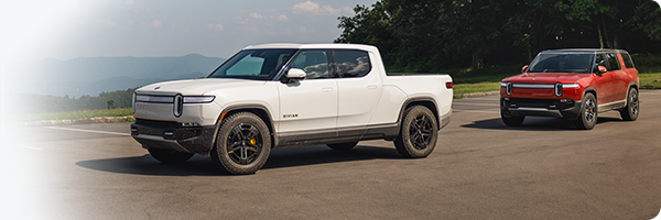 Both the Rivian R1T and the R1S stopped in a parked lot