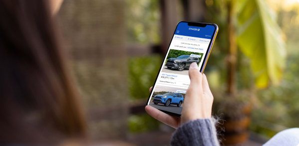 A woman browses cars on her smartphone