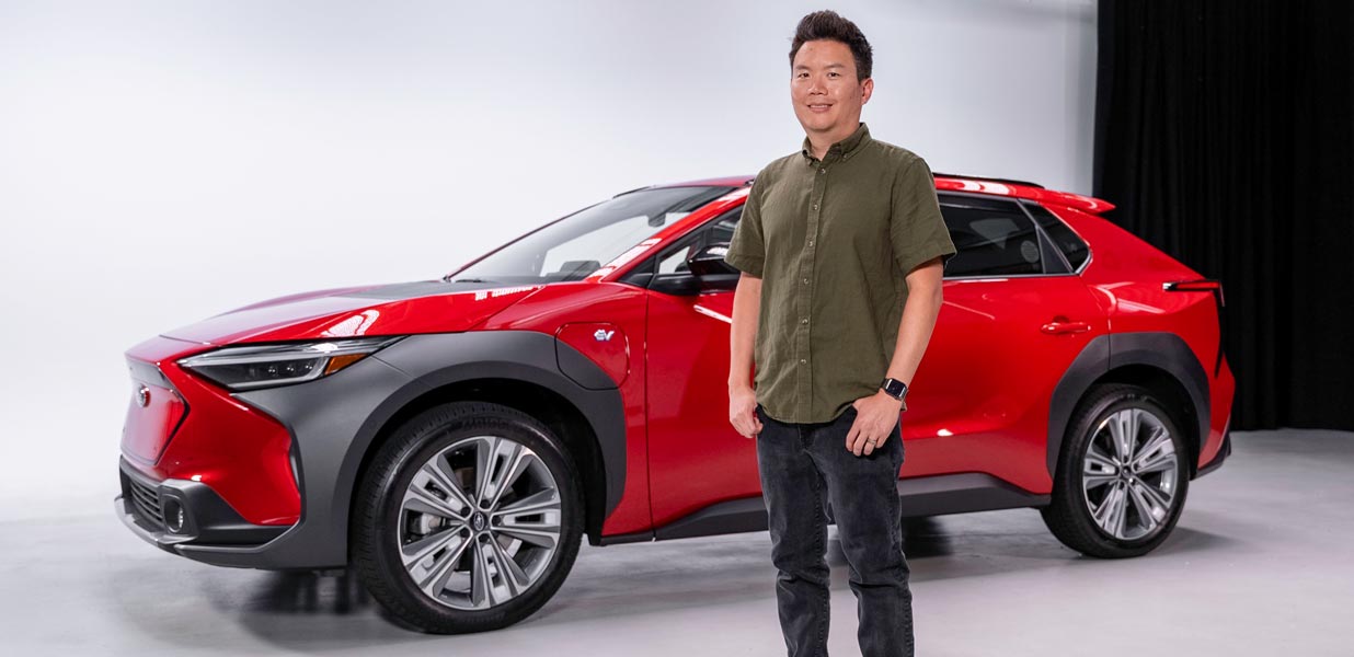Subaru's Garrick Goh standing in front of a red Subaru Solterra