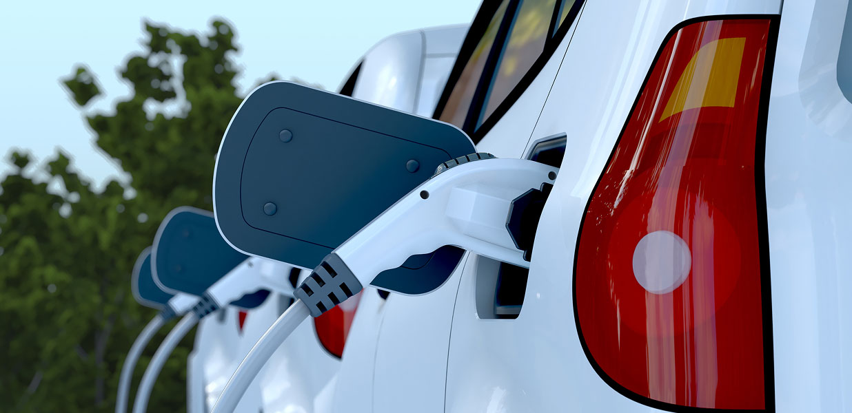 A close-up of a line of EVs charging