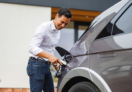 A man plugging in his hybrid vehicle