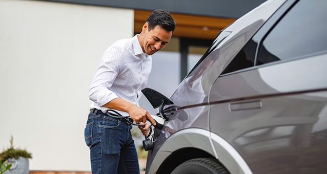 A man plugging in his hybrid vehicle