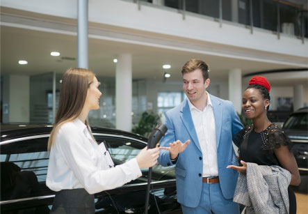 A sales representative showing a charging cable to prospective electric vehicle owners