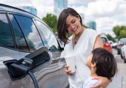 Mother and child smiling at each other while their electric vehicle charges