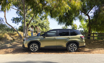 A couple standing by the roadside with their Subaru Forester