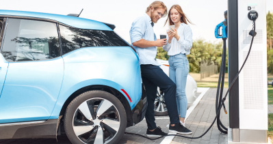A couple charging their Subaru electric vehicle at a charging station