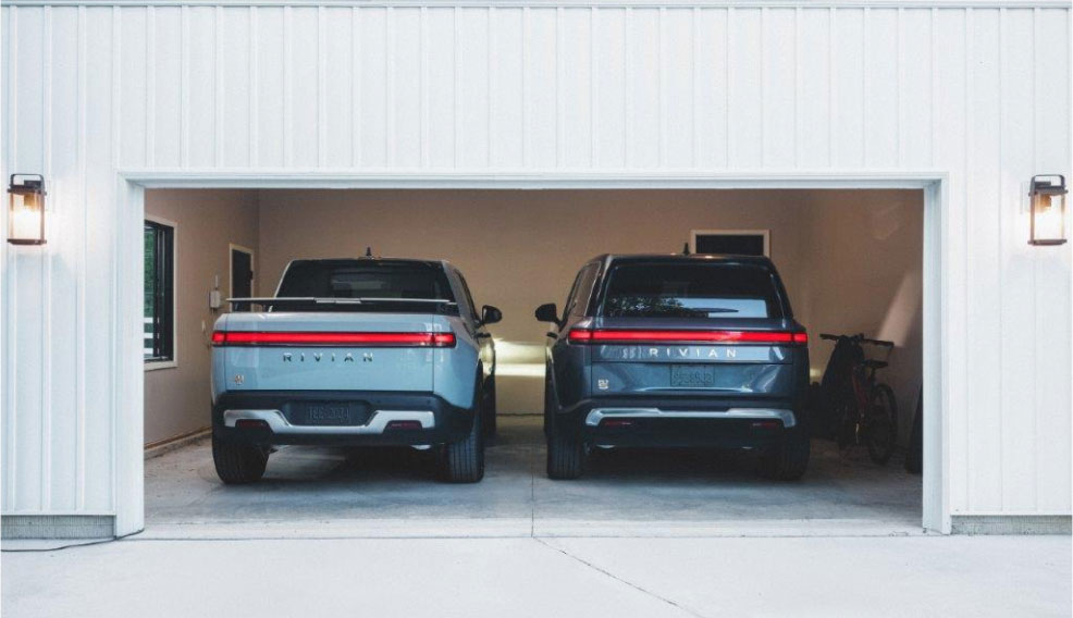 A Rivian R1S and R1T parked in an open garage