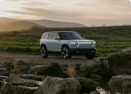 Rivian's latest electric mid-size SUV, the R2, parked in the wilderness